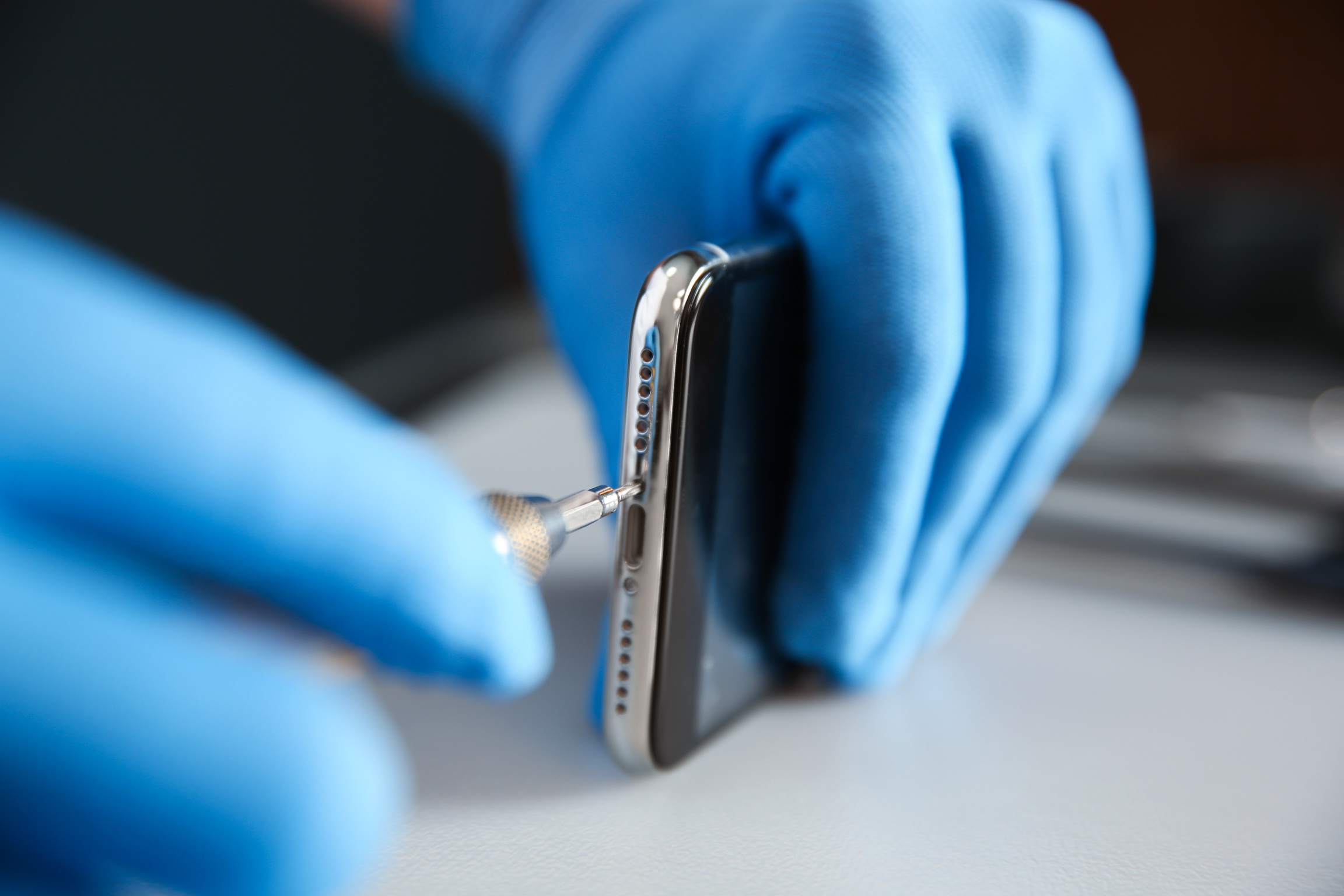Technician Repairing Mobile Phone at Table, Closeup